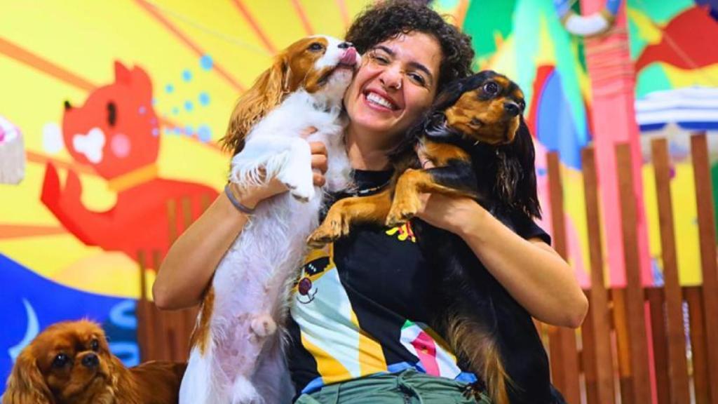 Dos perros en brazos de una educadora.