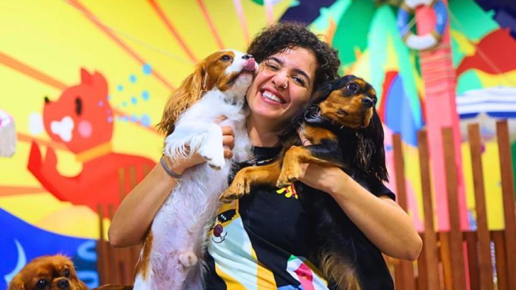 Dos perros en brazos de una educadora.