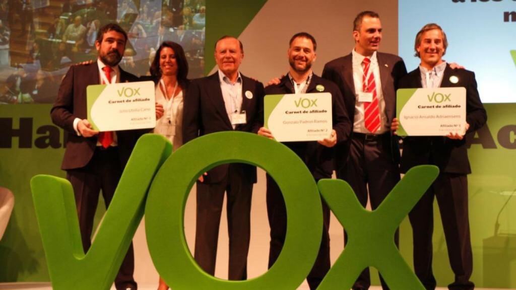 En la imagen, tomada en la primera Asamblea de Vox en enero de 2014, Enrique Cabanas recoge el carné de afiliado de Julio Utrilla (nº3), junto a Ana Velasco, Ignacio Camuñas, Gonzalo Padrón Ramos (nº2), Javier Ortega Smith e Ignacio Ansaldo Adriansens (nº1).