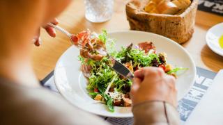 Imagen de una chica tomando una ensalada.