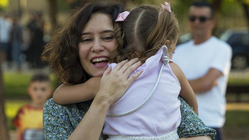 Isabel Díaz Ayuso abrazada a una niña tras un mitin.