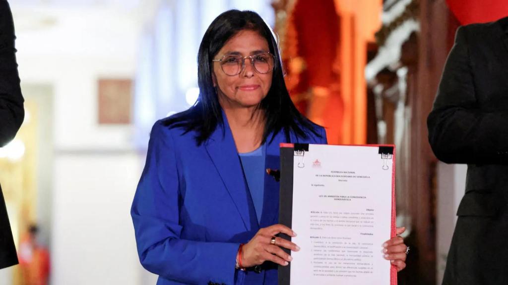 The interim president of Venezuela, Delcy Rodríguez, holds the text of the amnesty law