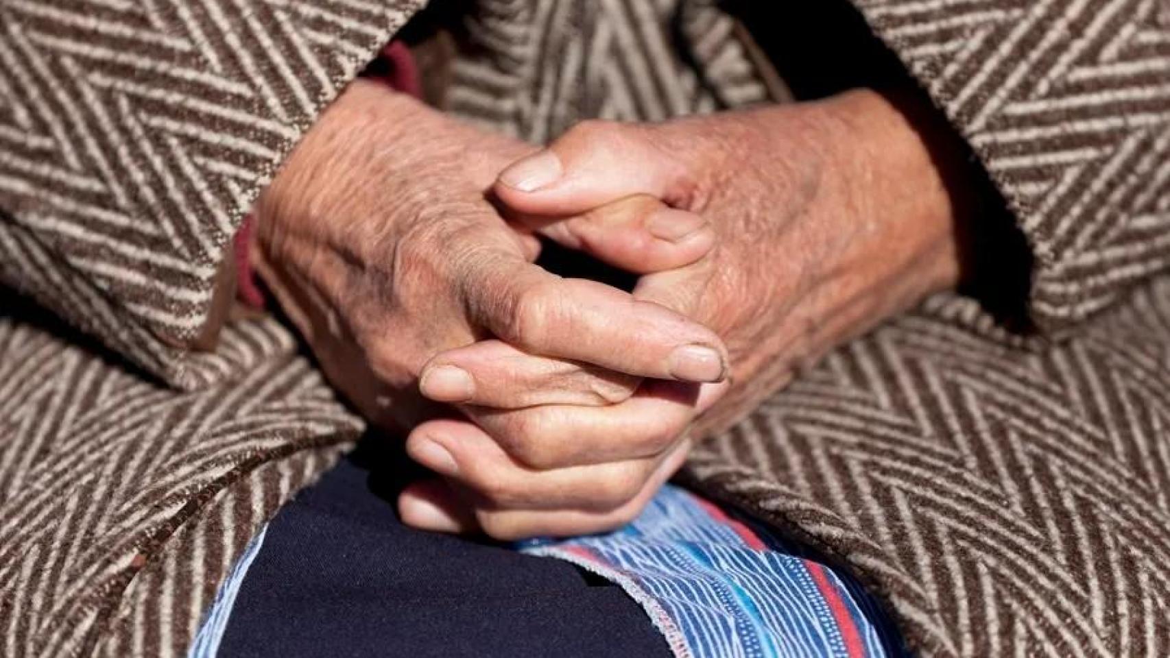 Una anciana sentada en un banco.