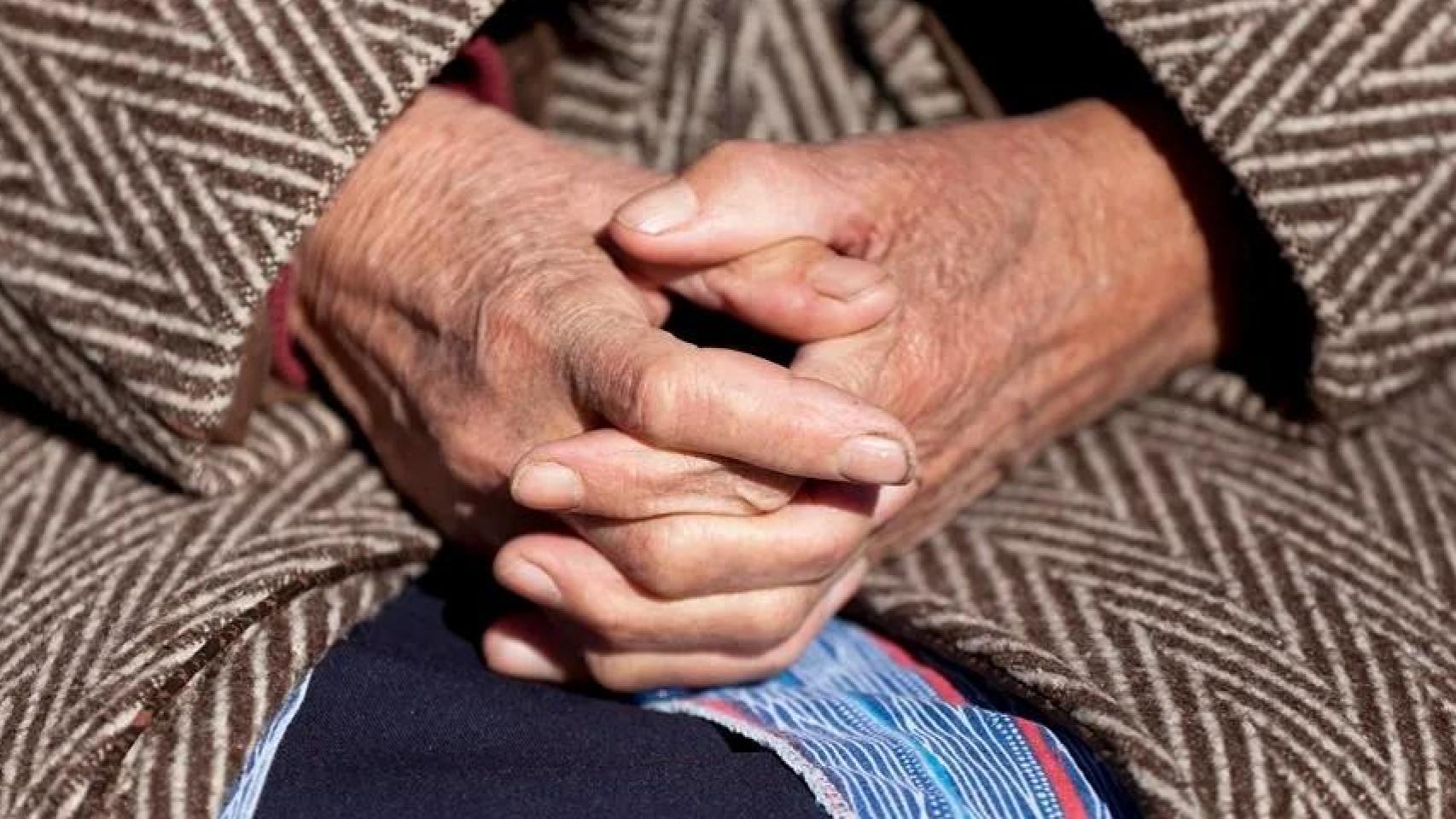 Una anciana sentada en un banco.