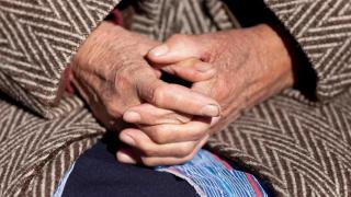 Una anciana sentada en un banco.