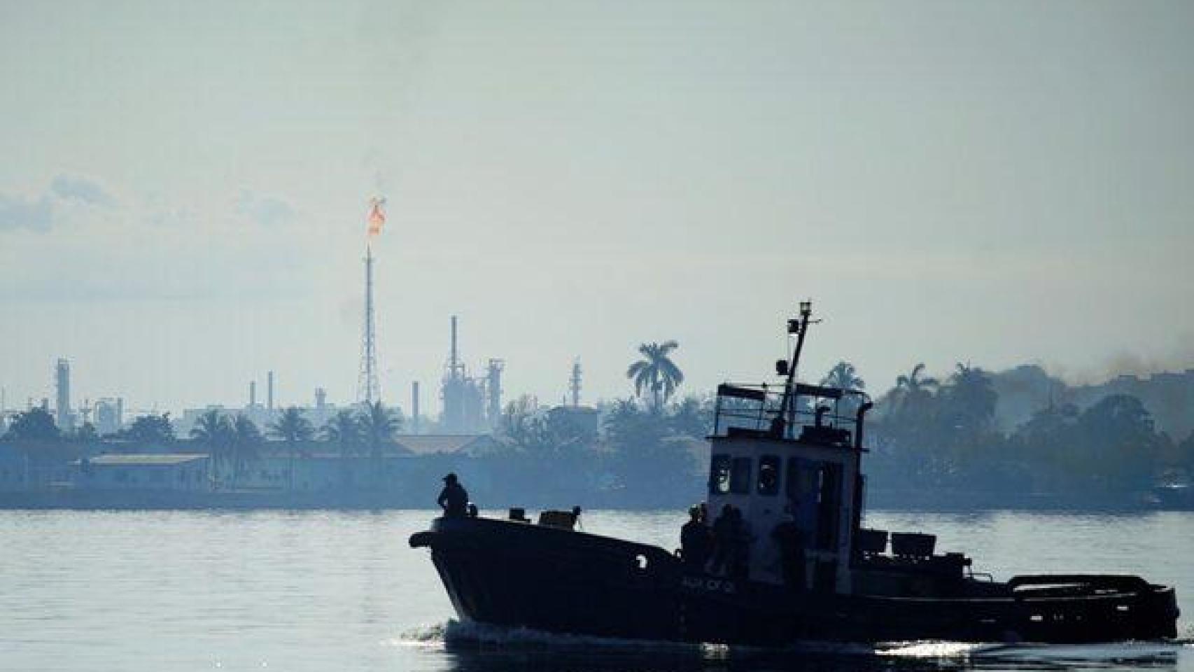 Un bote pasa frente a la refinería Ñico López en la bahía de La Habana.