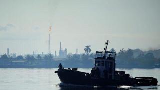 Un bote pasa frente a la refinería Ñico López en la bahía de La Habana.