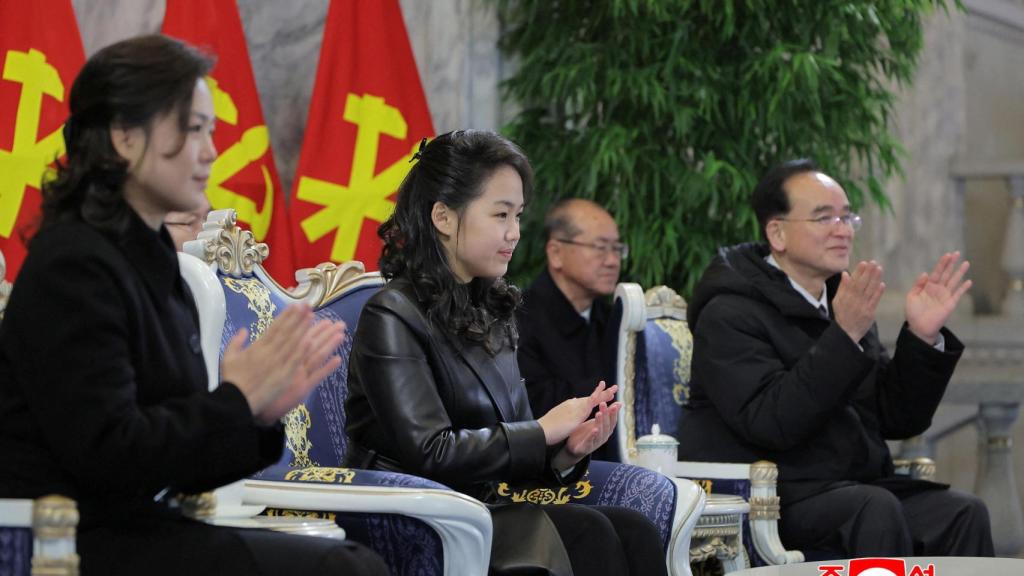 Kim Jong-un's daughter, center, applauds North Korean troops during the military parade.