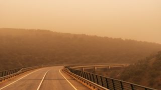 Viaducto entre montañas con calima