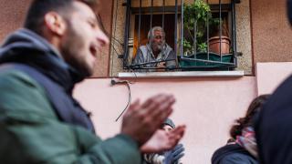 El propietario de un piso mira una manifestación desde su ventana.