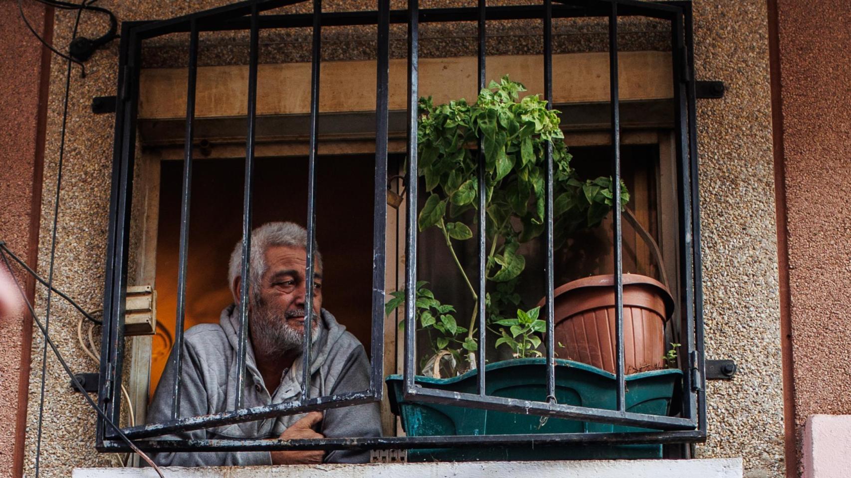 El propietario de un piso mira una manifestación desde su ventana.
