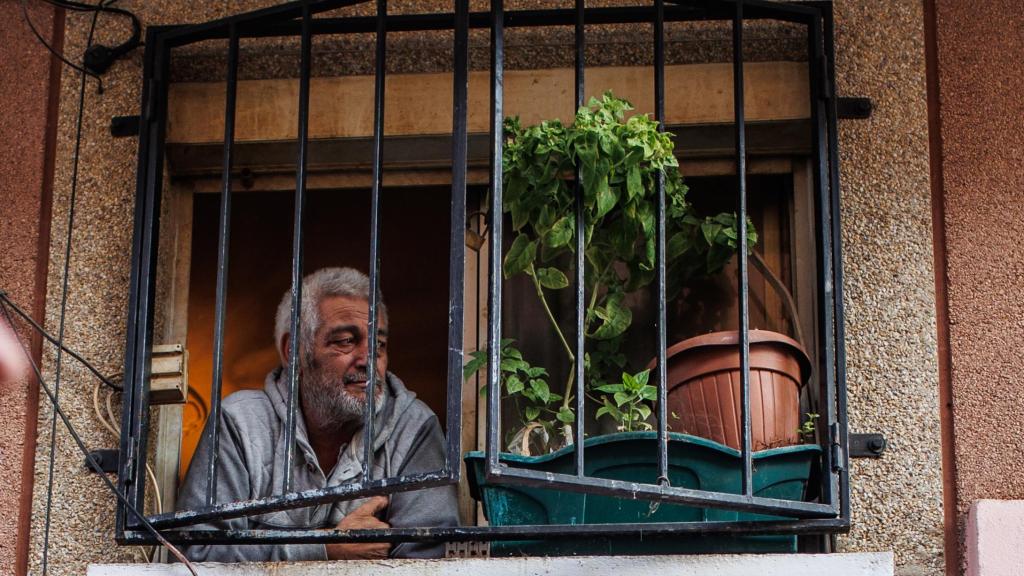 El propietario de un piso mira una manifestación desde su ventana.