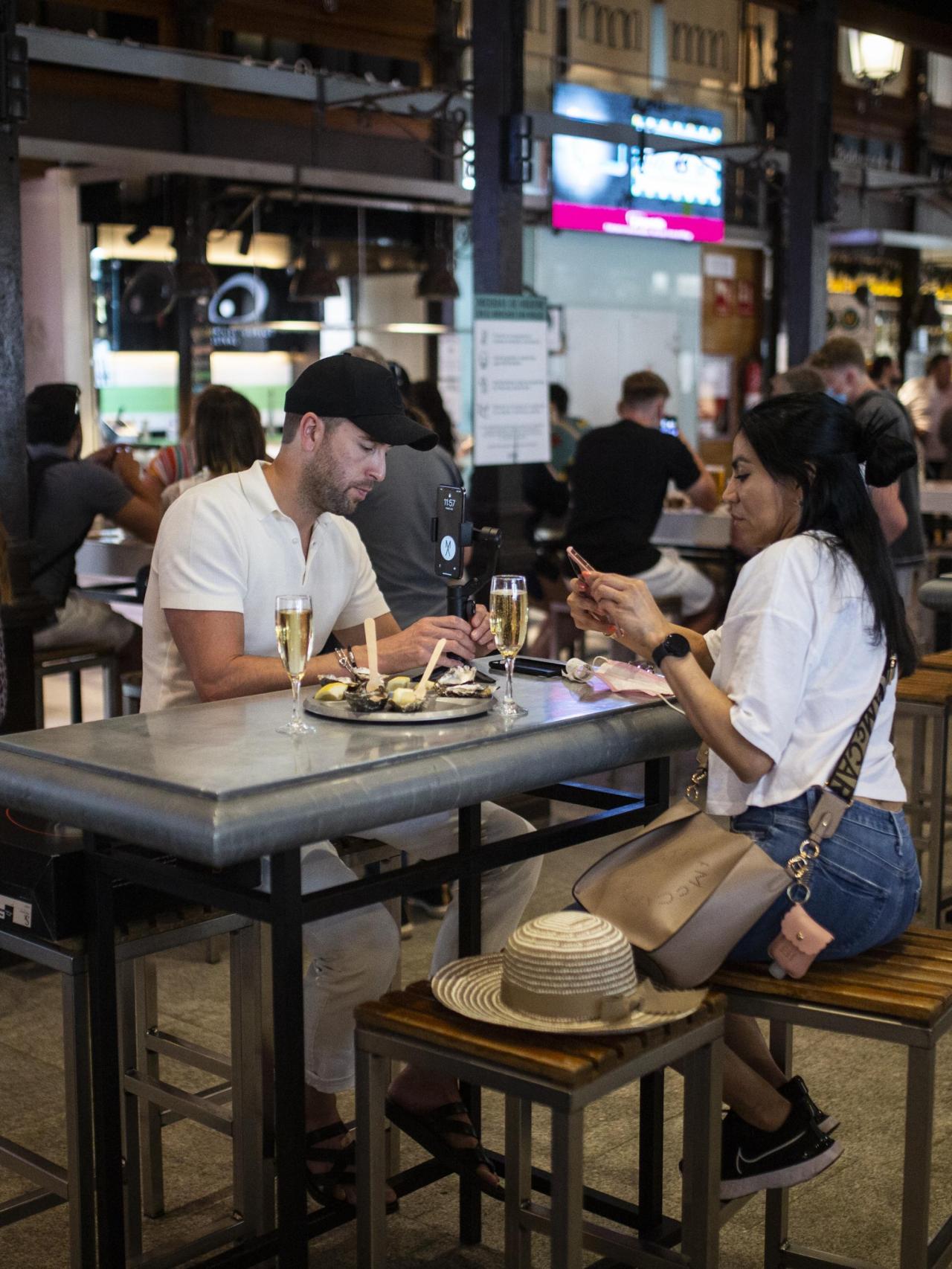 Dos chicos toman algo en el Mercado de San Miguel de Madrid.