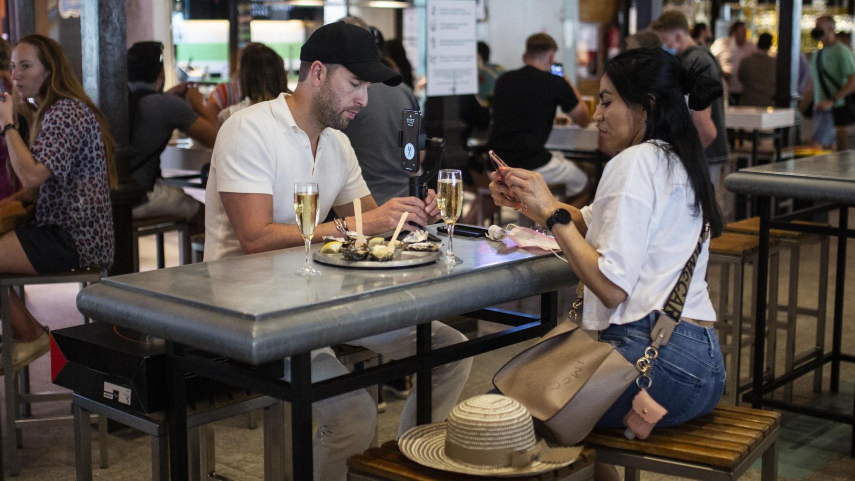 Dos chicos toman algo en el Mercado de San Miguel de Madrid.
