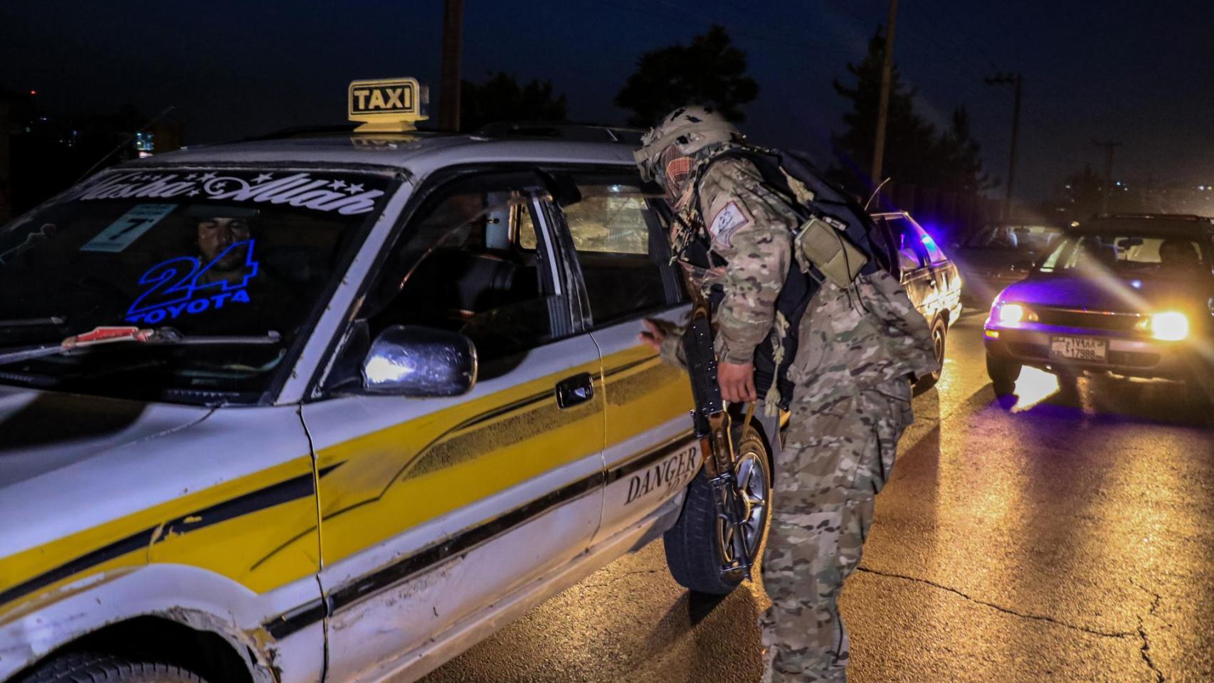 Un agente de seguridad talibán revisa un vehículo en un puesto de control en Kabul,