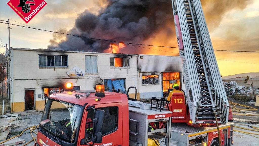Los bomberos trabajando en la extinción del incendio en la nave industrial.