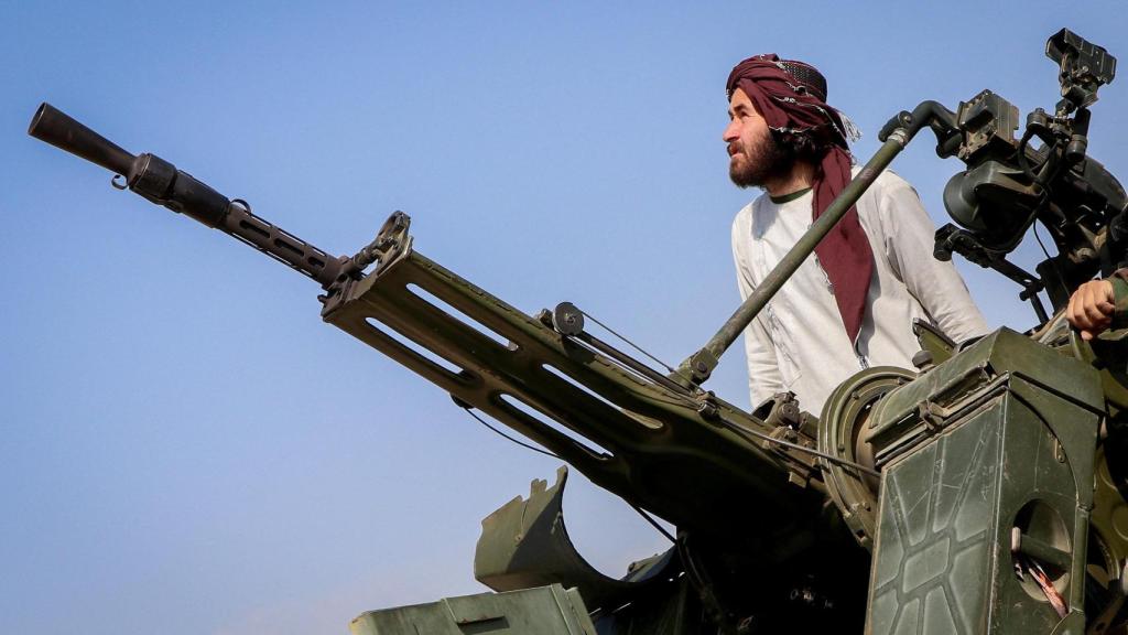 Un soldado talibán permanece junto a un cañón antiaéreo mientras vigila la posible presencia de cazas paquistaníes, en la provincia de Jost, Afganistán.