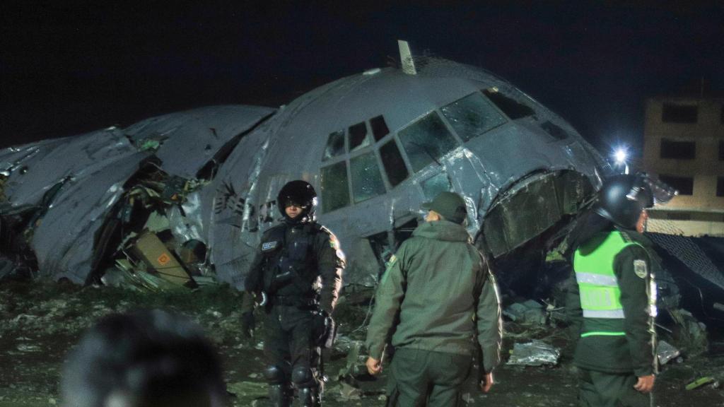 Fuerzas militares de Bolivia custodian el avión militar de carga que se ha estrellado en el aeropuerto de El Alto.
