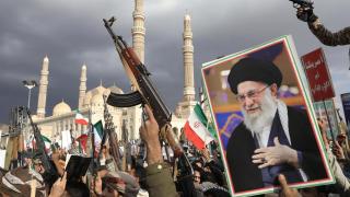 Partidarios hutíes muestran sus armas y un retrato del líder supremo iraní, el ayatolá Ali Khamenei, durante una protesta contra los ataques estadounidenses e israelíes contra Irán.