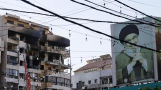 A building in Beirut damaged by an Israeli missile next to a poster of Hasan Nasrallah, former leader of Hezbollah.