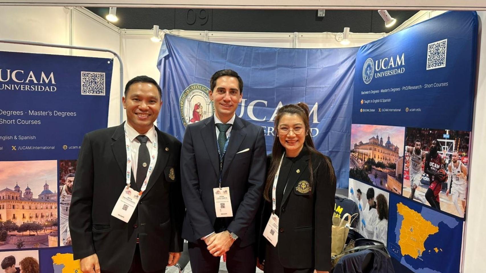 Enrique López, responsable de Alianzas Estratégicas de la UCAM, junto a representantes asiáticos en el stand de la universidad