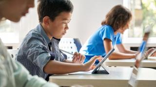 Niño con una tablet haciendo los deberes.
