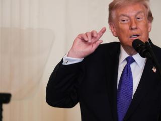 Donald Trump gestures while listening to construction noise during a Medal of Honor ceremony at the White House.