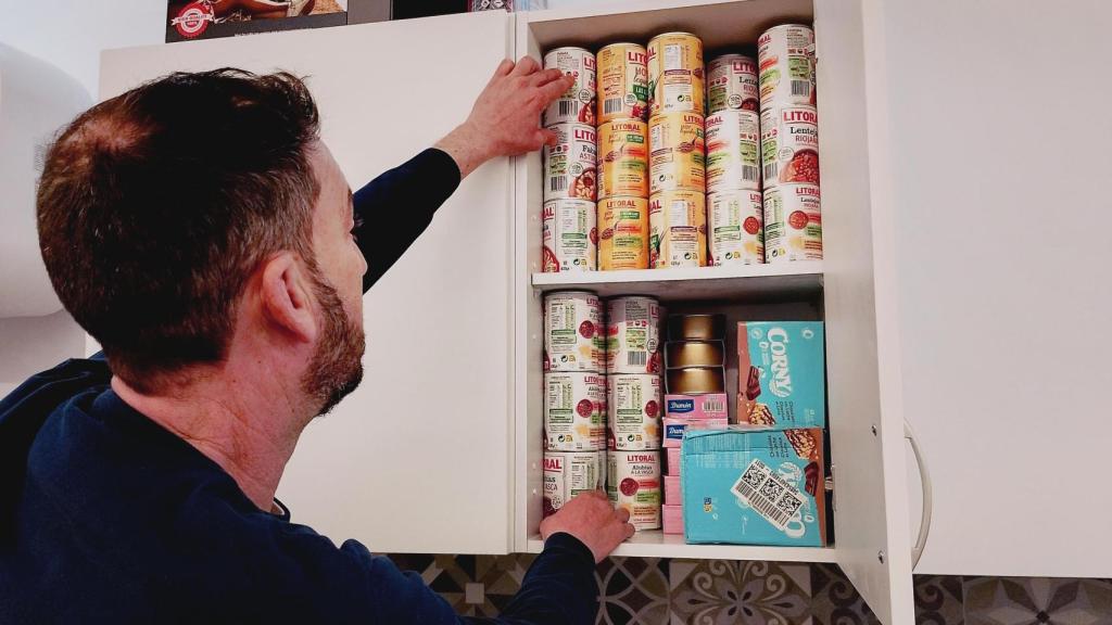 Ignacio mostrando las latas de comida  en conserva que almacena un armario del búnker.