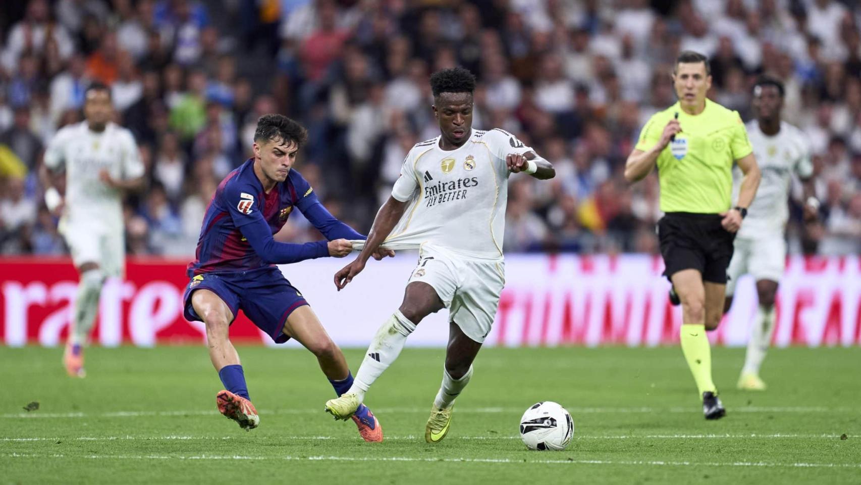 Pedri agarra a Vinicius durante el último Clásico.