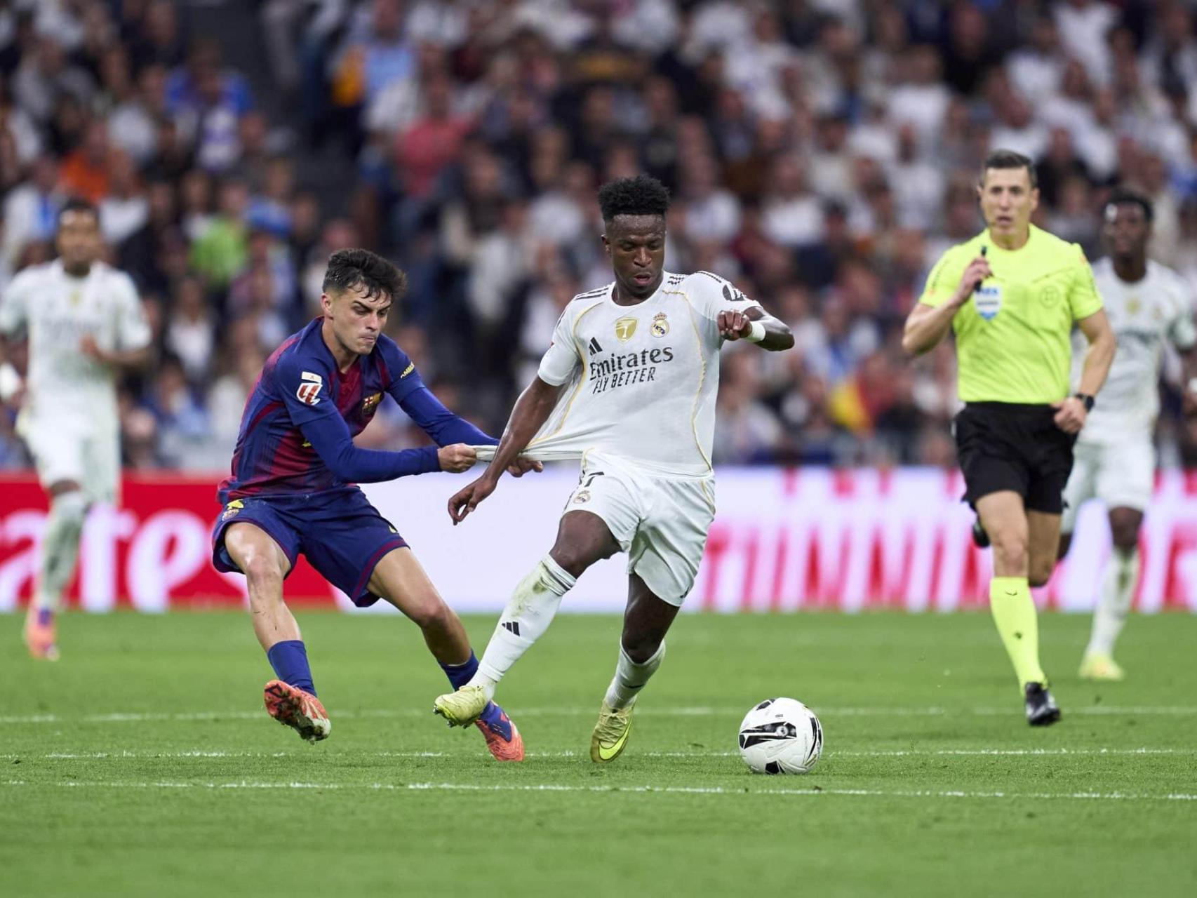 Pedri agarra a Vinicius durante el último Clásico.