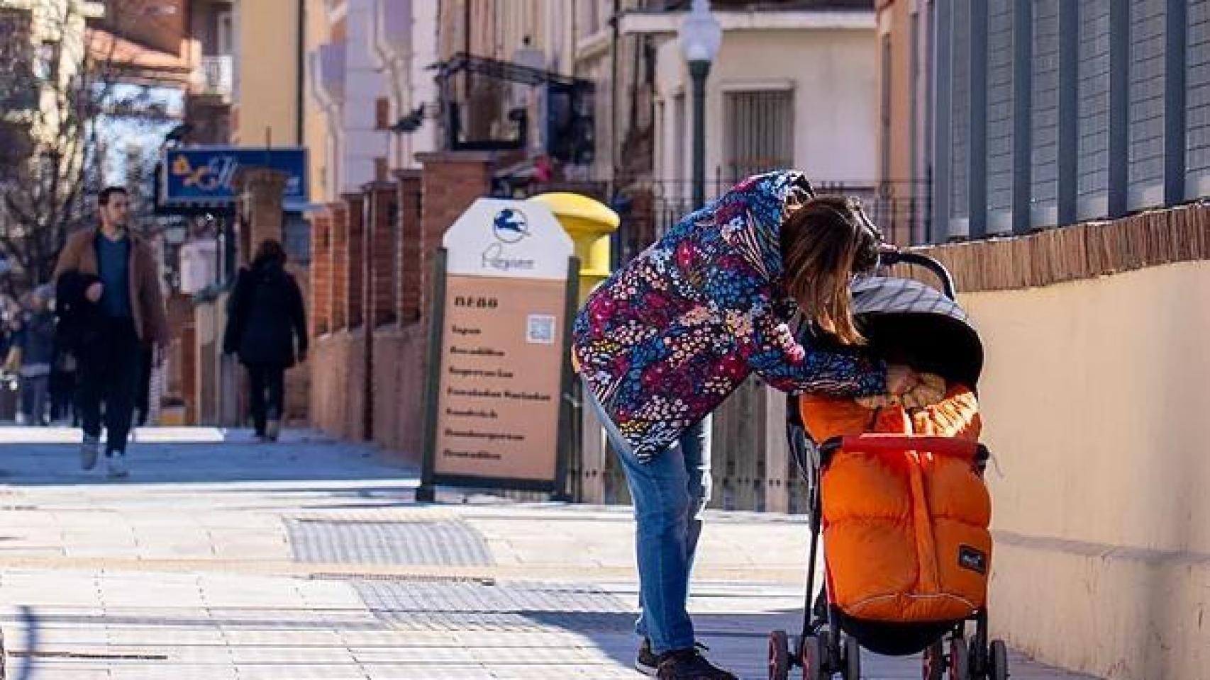 Una mujer pasea a su hijo.