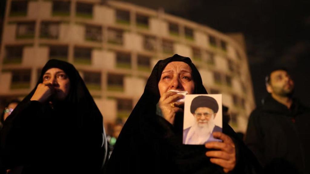 Una mujer sostiene una foto de Ali Jamenei en Vali-Asr Square, Teherán, tras su muerte.