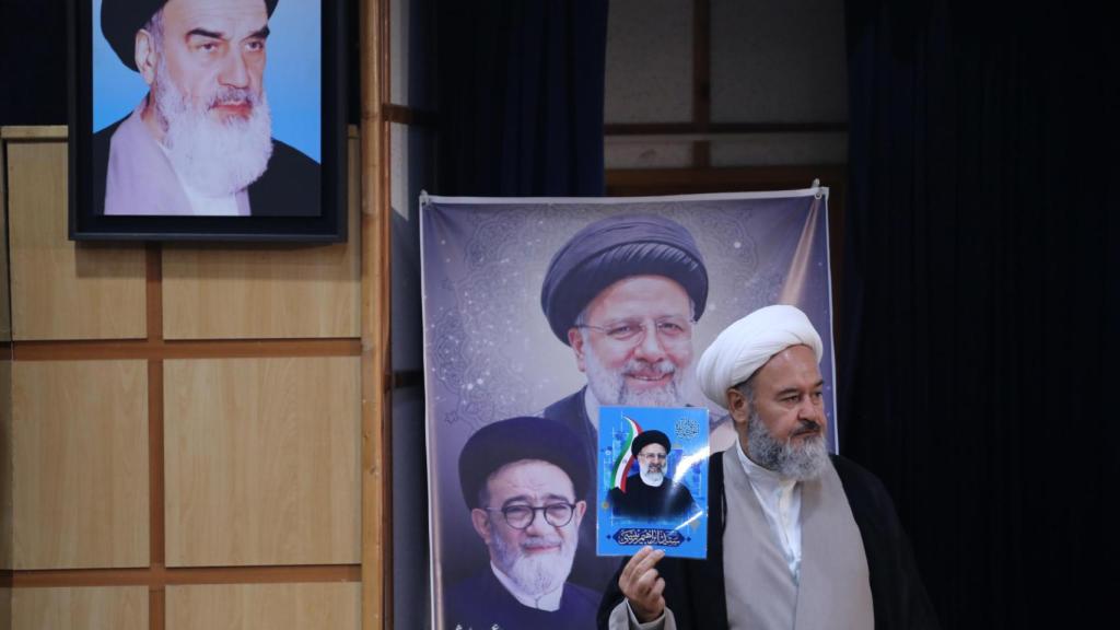 Ahmad Akbari mostrando un retrato de Ebrahim Raisi al registrar su candidatura presidencial en Teherán.