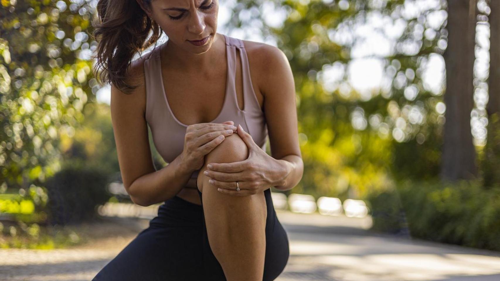 Mujer joven sintiendo dolor en la rodilla.