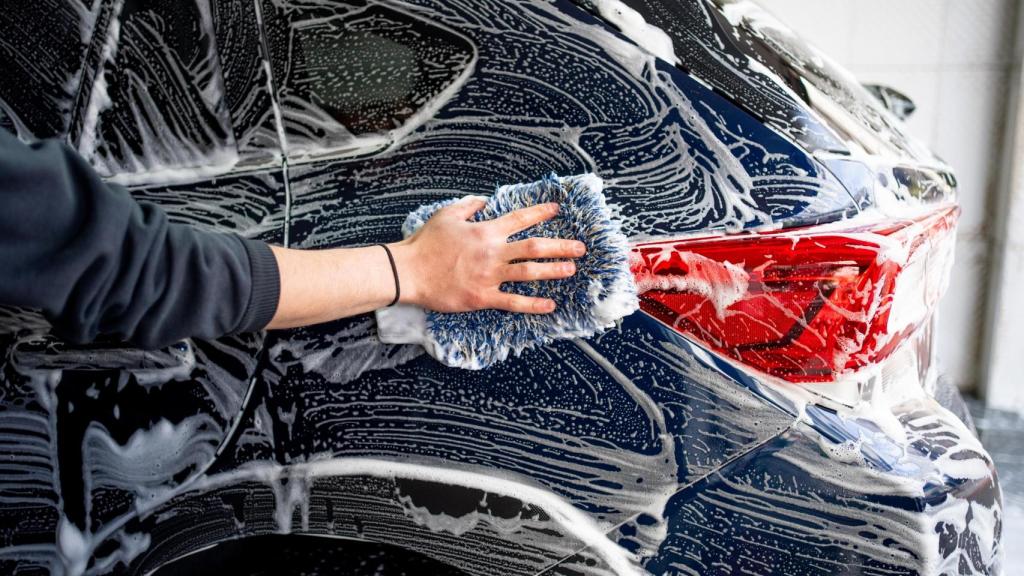 Una persona lava un coche