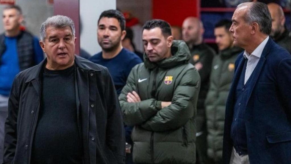 Xavi Hernández y Deco, de fondo, escuchando una charla de Laporta en el vestuario