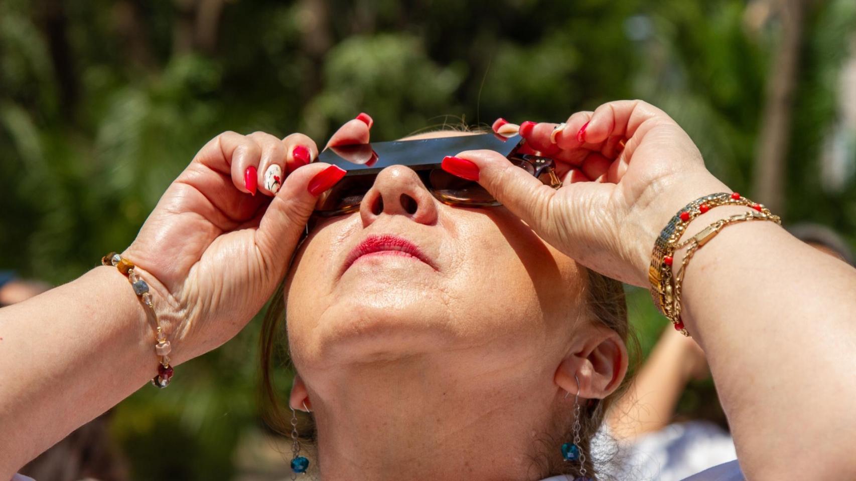 Una mujer observa un eclipse de Sol