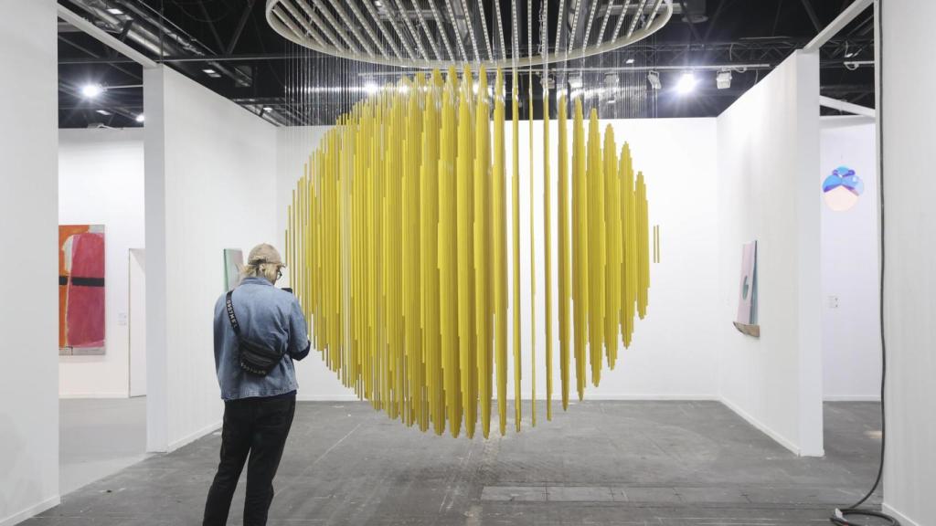 Una mujer observa la obra Esfera Amarilla 1984, del artista Jesús R. Soto en la Galería Elvira González.