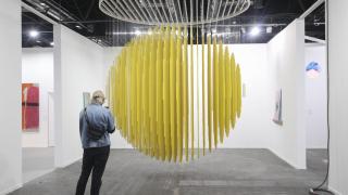 Una mujer observa la obra Esfera Amarilla 1984, del artista Jesús R. Soto en la Galería Elvira González.