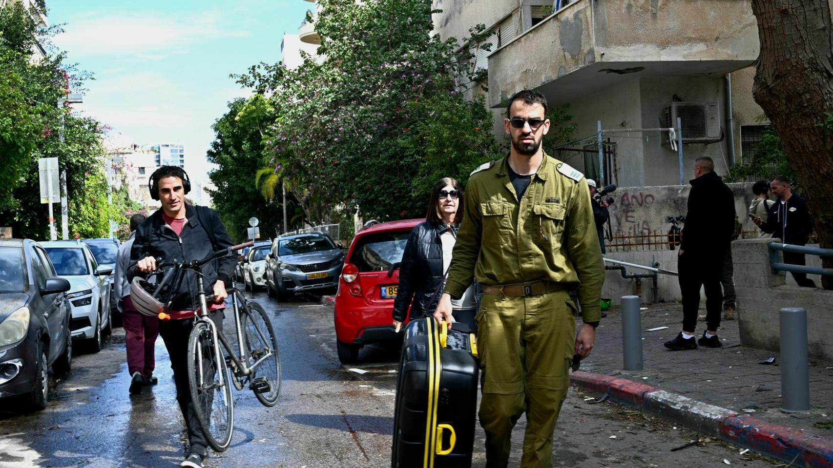 Los residentes de un edificio en Tel Aviv recogen sus pertenencias personales en la segunda mañana de la guerra con Irán.