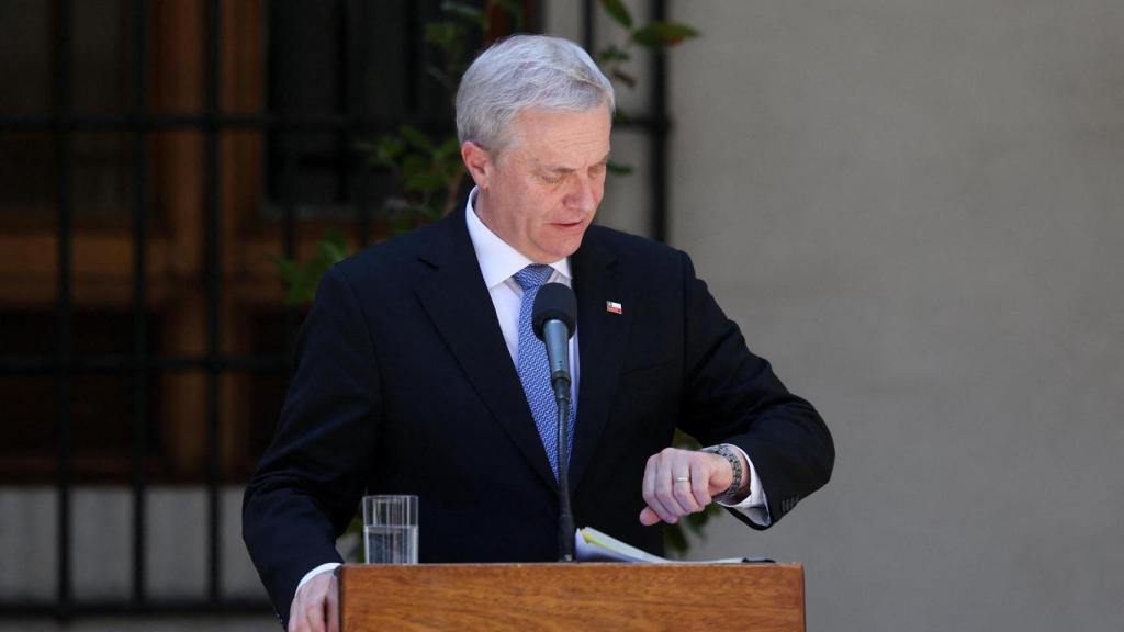 El presidente electo, Jose Antonio Kast revisa su reloj durante un acto en la Moneda junto al presidente saliente, Gabriel Boric.
