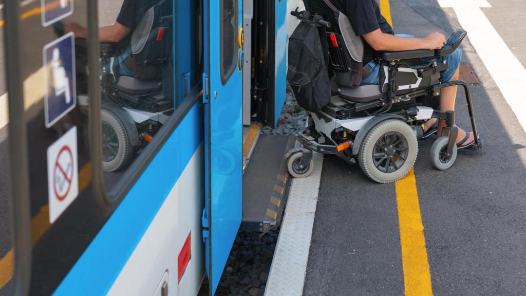 Un hombre discapacitado aborda el tren en silla de ruedas.