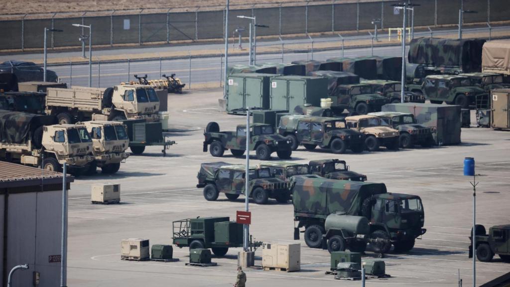 A US Army soldier walks past military vehicles at a US military base in Pyeongtaek, South Korea.