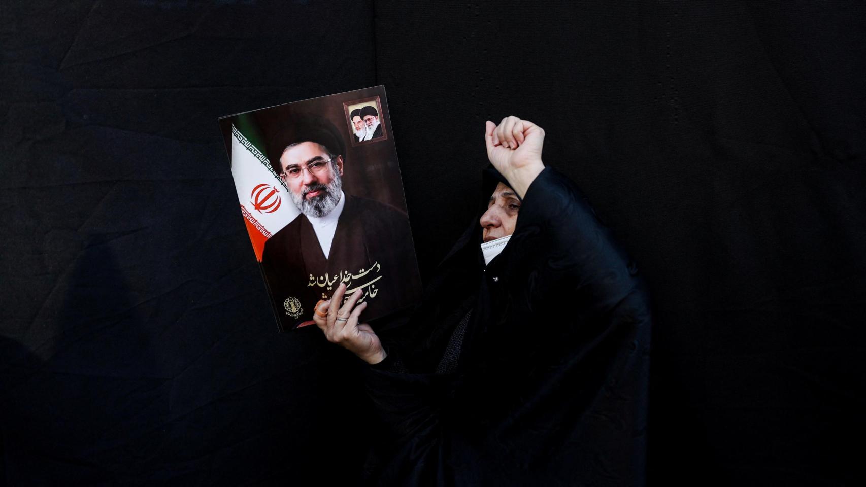Una mujer sostiene una imagen de Mojtaba Jamenei en una marcha en Teherán.