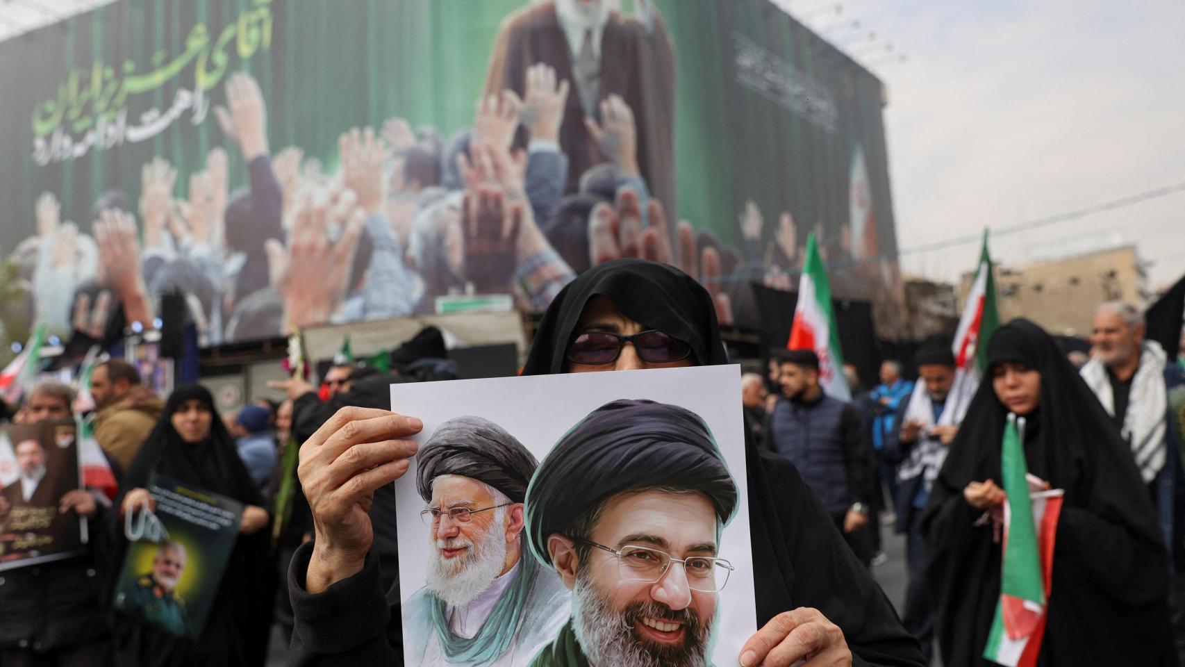 Una mujer sostiene una imagen del nuevo líder supremo, Mojtaba Jamenei, junto al difunto líder iraní, Ali Jamenei, este miércoles durante una ceremonia fúnebre por los comandantes militares iraníes que murieron en ataques de EEUU e Israel.
