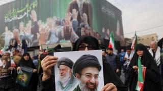 A woman holds an image of the new supreme leader, Mojtaba Khamenei, next to the late Iranian leader, Ali Khamenei, on Wednesday during a funeral ceremony for Iranian military commanders who died in US and Israeli attacks.