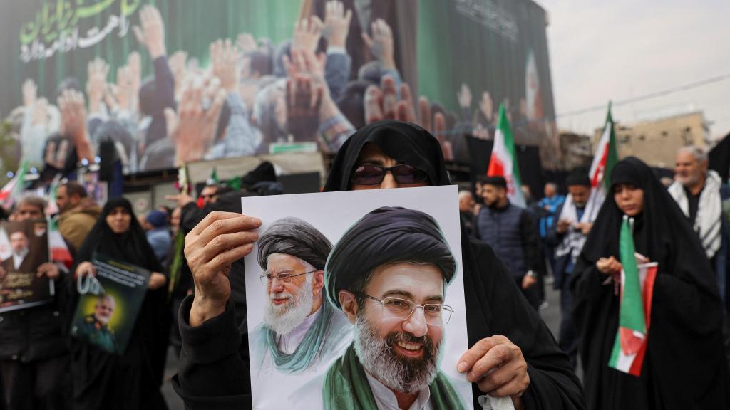 Una mujer sostiene una imagen del nuevo líder supremo, Mojtaba Jamenei, junto al difunto líder iraní, Ali jamenei, este miércoles durante una ceremonia fúnebre por los comandantes militares iraníes que murieron en ataques de EEUU e Israel.