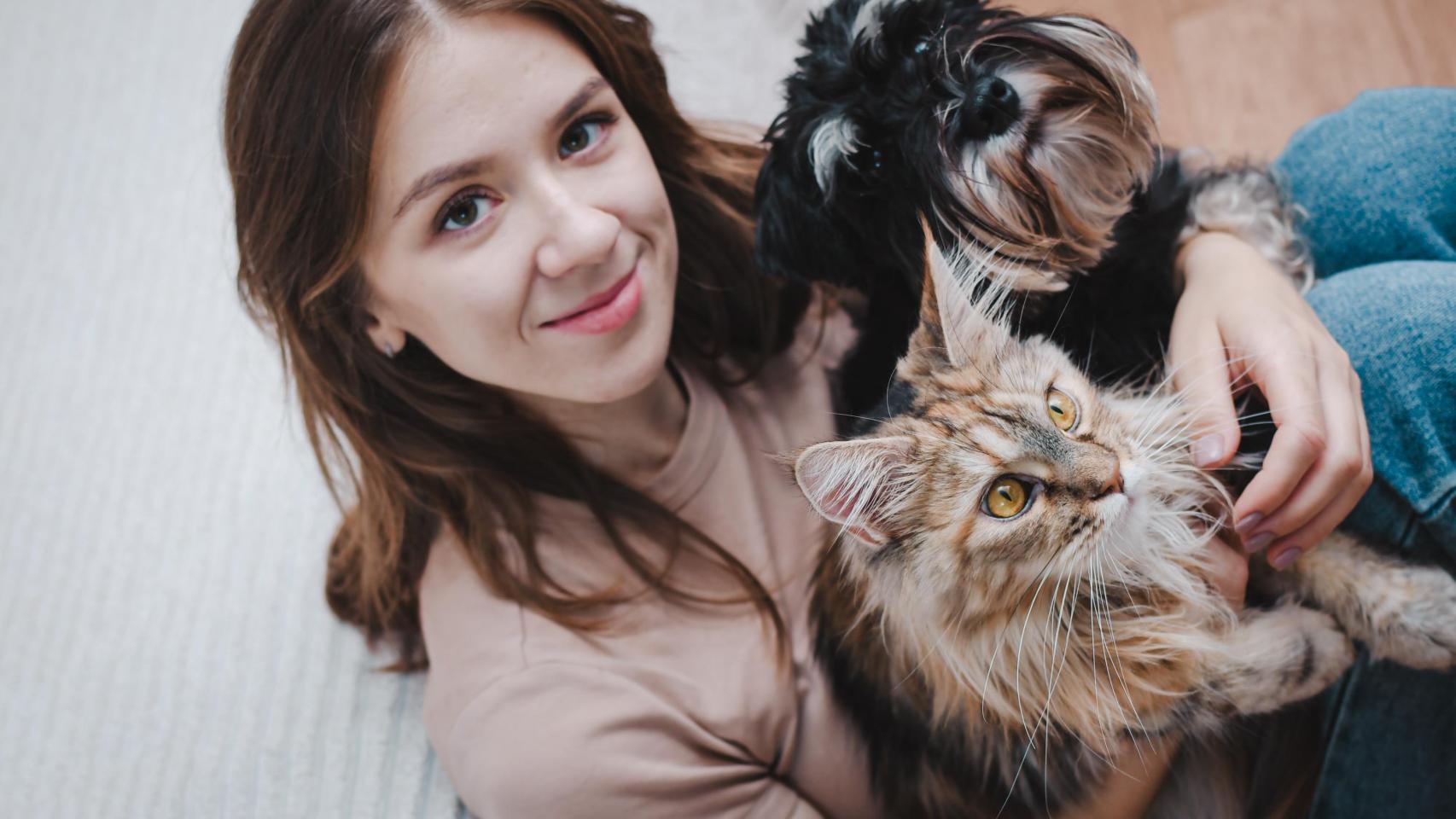 Una mujer con un perro y gato.