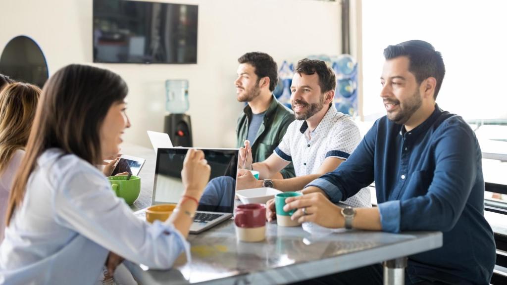 Grupo de empleados comiendo en su puesto de trabajo