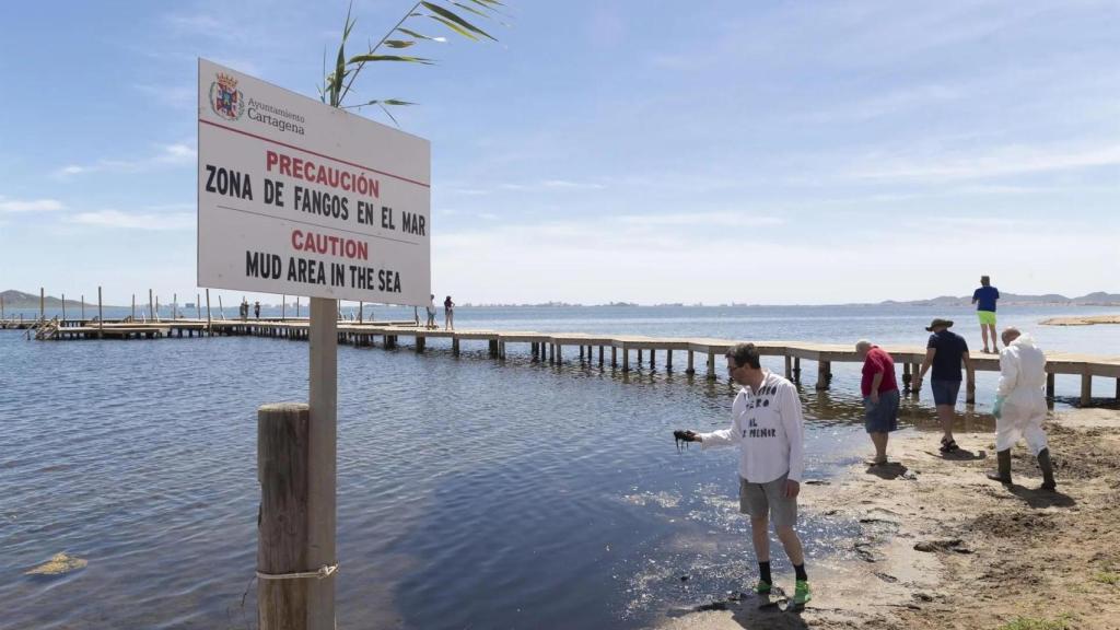 Trabajadores inspeccionando el agua, reflejo de la degradación por contaminación. EFE